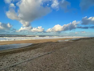 a sandy beach with waves in the ocean at 10 person holiday home in Harboøre-By Traum in Harboør