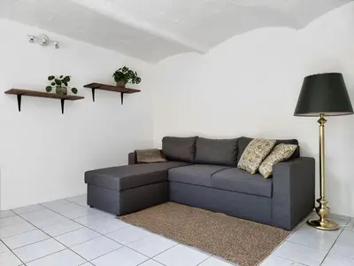 a living room with a couch and a lamp at Calm and idyllic surroundings in Northen Jutland in Nibe