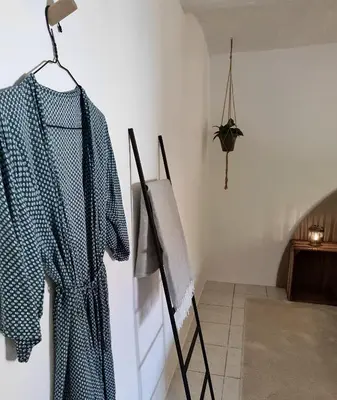 a shirt hanging on a wall next to a painting at Calm and idyllic surroundings in Northen Jutland in Nibe