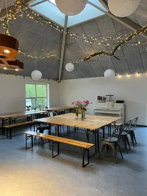 a large room with tables and chairs and lights at Room 8 - Hawkraft kulturhotel in Vestervig