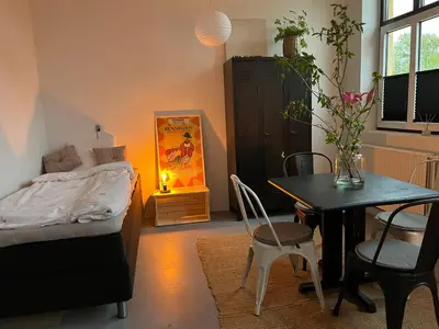 a bedroom with a bed and a table and chairs at Room 9 -Hawkraft kulturhotel in Vestervig