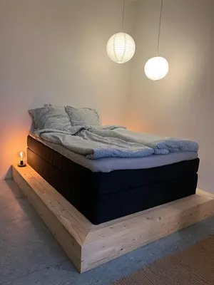 a bed sitting on a wooden platform in a room at Room 12 - Hawkraft Kulturhotel in Vestervig