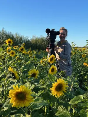 a man holding a camera in a field of sunflowers at Room 12 - Hawkraft Kulturhotel in Vestervig