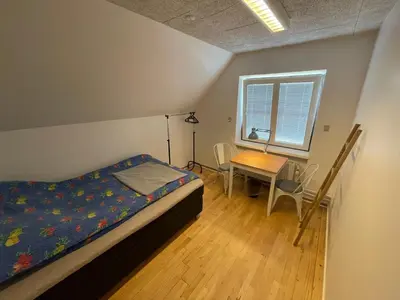 a bedroom with a bed and a table and a window at Room 18 - Hawkraft kulturhotel in Vestervig
