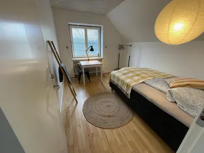 a bedroom with a bed and a desk and a window at Room 19 - Hawkraft kulturhotel in Vestervig