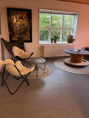 a living room with chairs and a table and a window at Room 19 - Hawkraft kulturhotel in Vestervig