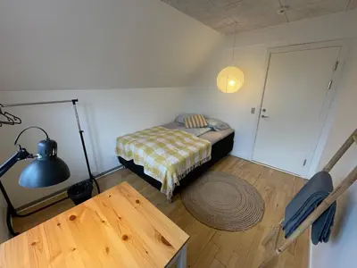 a small bedroom with a bed and a table at Room 19 - Hawkraft kulturhotel in Vestervig