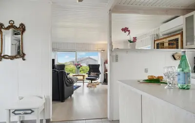a kitchen and living room with a table and chairs at Stunning Home In Løkken With Sauna in Løkken
