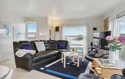 a living room with a leather couch and a table at Stunning Home In Løkken With Sauna in Løkken