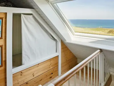 a room with a window and a balcony with the ocean at Holiday Home Alkmar - 75m from the sea by Interhome in Thisted