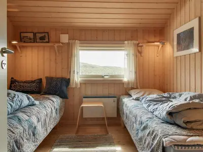 a small room with two beds and a window at Holiday Home Eunike - 220m from the sea by Interhome in Løkken