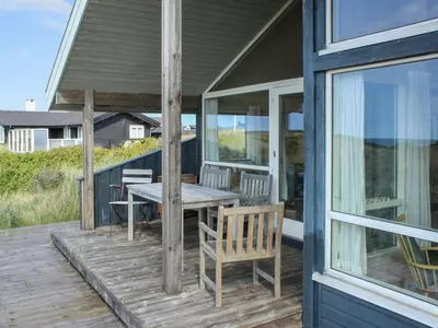 a porch with a table and chairs on it at Holiday Home Eunike - 220m from the sea by Interhome in Løkken