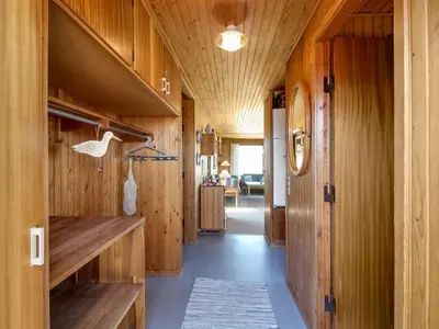 a hallway of a house with wooden walls and floors at Holiday Home Mira - 375m from the sea by Interhome in Løkken
