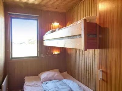 a small room with a bunk bed and a window at Holiday Home Mira - 375m from the sea by Interhome in Løkken