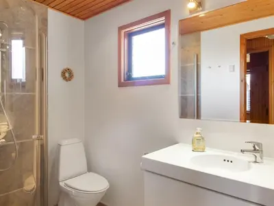 a bathroom with a toilet and a sink and a shower at Holiday Home Mira - 375m from the sea by Interhome in Løkken
