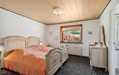 a bedroom with a large bed and a window at Nice Home In Bækmarksbro With Wifi in Bækmarksbro