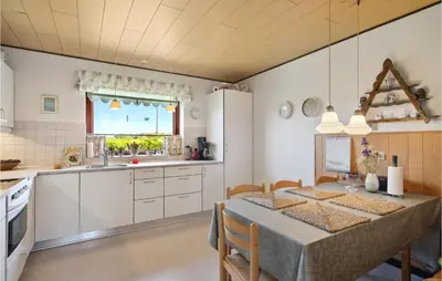 a kitchen with a table and a dining room at Nice Home In Bækmarksbro With Wifi in Bækmarksbro