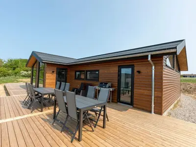 a cabin with a table and chairs on a deck at 10 person holiday home in Saltum-By Traum in Saltum