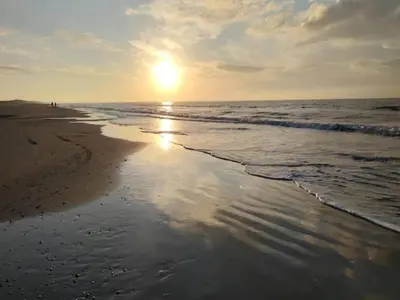a beach with the sun rising over the ocean at 10 person holiday home in Saltum-By Traum in Saltum