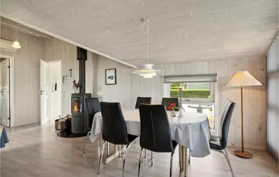 a dining room with a table and black chairs at 3 Bedroom Gorgeous Home In Farsø in Farsø
