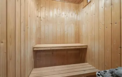 a wooden sauna with a wooden shelf in it at Cozy Home In Farsø With Sauna in Farsø
