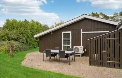 a table and chairs in front of a building at Cozy Home In Farsø With Sauna in Farsø