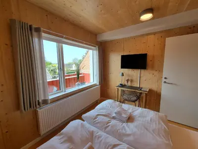 a bedroom with a bed and a window and a television at Skovsgård Hotel in Brovst