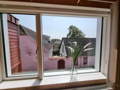a window with a vase sitting on a window sill at Skovsgård Hotel in Brovst