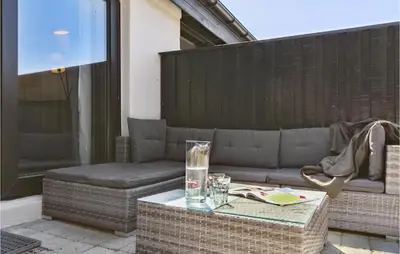 a patio with a couch and a table at Nice Apartment In Blokhus With Wifi in Blokhus