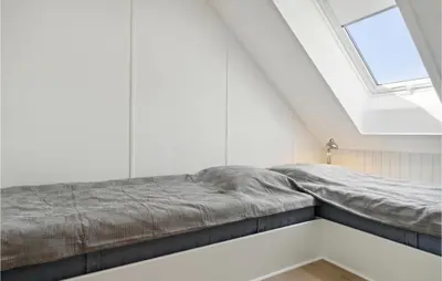 a bed in a white room with a window at Nice Apartment In Blokhus With Wifi in Blokhus