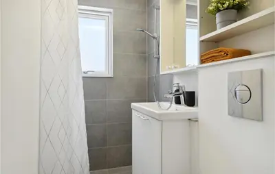 a white bathroom with a sink and a shower at Nice Apartment In Blokhus With Wifi in Blokhus