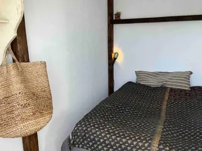 a bedroom with a bed with a black and white comforter at The Old Soap House - stylish and close to beach in Vang