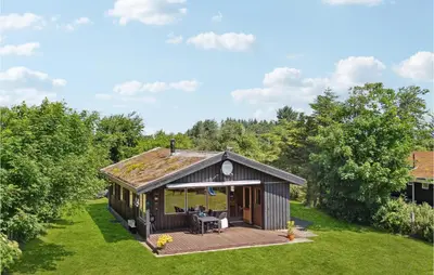a small cabin with a deck in a yard at Gorgeous Home In Blokhus With Wifi in Blokhus