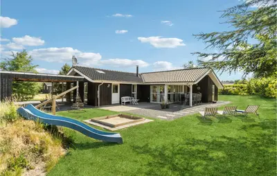 a backyard with a slide and a house at Gorgeous Home In Fjerritslev With Sauna in Fjerritslev