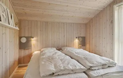a large bed in a room with wooden walls at Gorgeous Home In Fjerritslev With Sauna in Fjerritslev