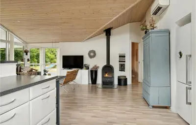 a kitchen with white cabinets and a wood stove at Gorgeous Home In Fjerritslev With Sauna in Fjerritslev