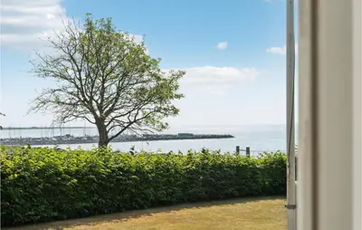 a window view of a tree and the water at Amazing Home In Vesløs in Øsløs