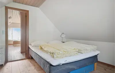 an unmade bed in a room with a window at Amazing Home In Vesløs in Øsløs