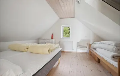 a white bedroom with two beds and a window at Amazing Home In Vesløs in Øsløs