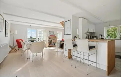 a kitchen and living room with a table and chairs at Amazing Home In Vesløs in Øsløs