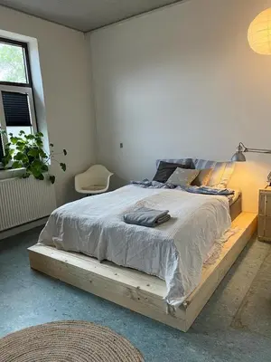 a bed with a wooden frame in a bedroom at Room 7 - Hawkraft kulturhotel in Vestervig