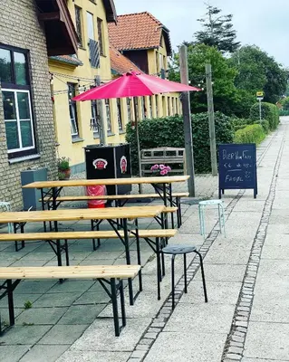 a picnic table with an umbrella on a sidewalk at Room 14 - Hawkraft kulturhotel in Vestervig