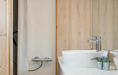 a bathroom with a white sink and a mirror at Beautiful Home In Thyborøn With Sauna in Thyborøn