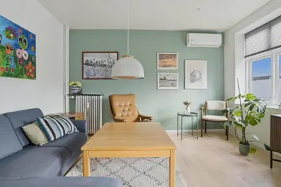 a living room with a blue couch and a table at Apartment in central Holstebro in Holstebro