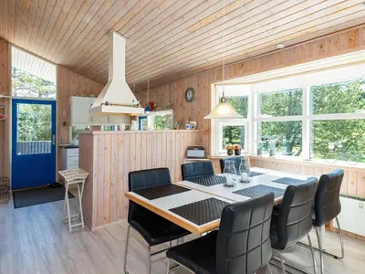 a kitchen and dining room with a table and chairs at 6 person holiday home in Pandrup-By Traum in Pandrup