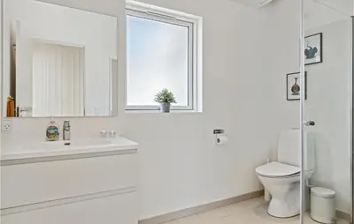 a white bathroom with a sink and a toilet at Nice Home In Blokhus With Kitchen in Blokhus