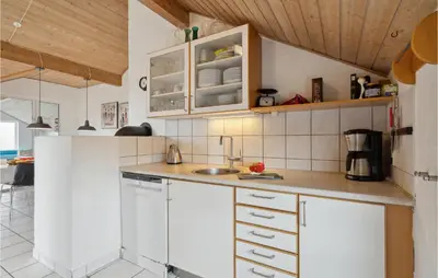 a kitchen with white cabinets and a sink at Nice Home In Vinderup With Sauna in Vinderup