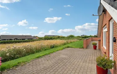 a brick walkway next to a house with flowers at Nice Home In Vinderup With Sauna in Vinderup