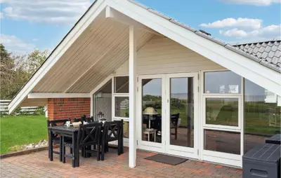a screened in patio with a table and chairs at 3 Bedroom Cozy Home In Løgstør in Løgsted
