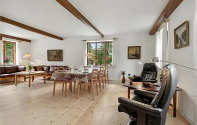 a living room with a table and chairs at Cozy Home In Brovst With Kitchen in Brovst